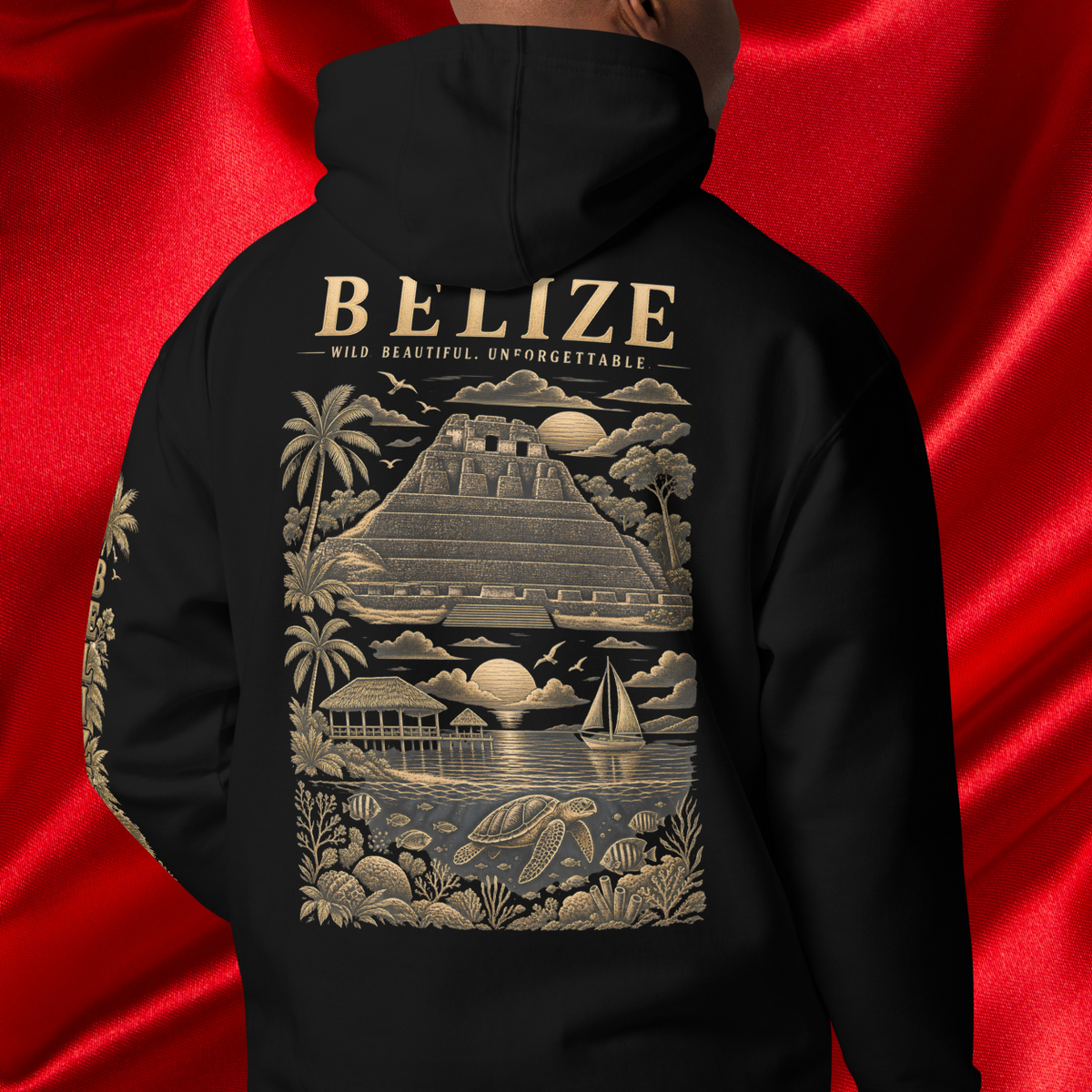 A person shown from the back wearing a black hoodie with a large beige graphic print featuring the word BELIZE, a pyramid, palm trees, sailboats, and tropical scenery. The background is a shiny red satin fabric.